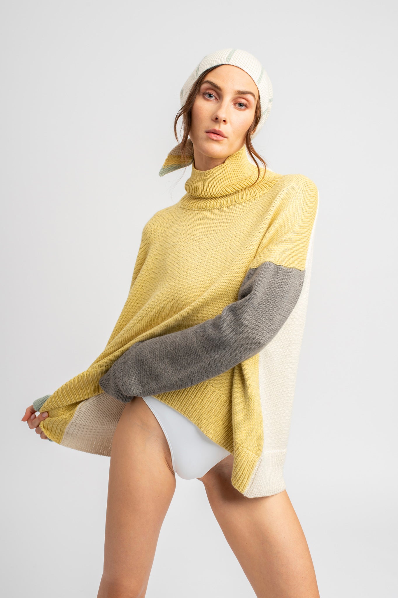 Model wearing turtleneck oversized sweater in multi-color yellow alpaca wool, front view