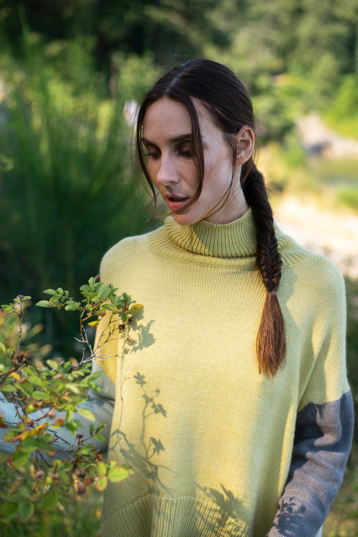 Model wearing turtleneck oversized sweater in multi-color yellow alpaca wool, close-up