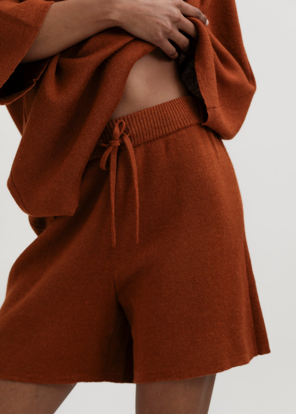 Airy Shorts in Burnt Orange, alpaca and silk knit shorts by Ahblo, worn by model