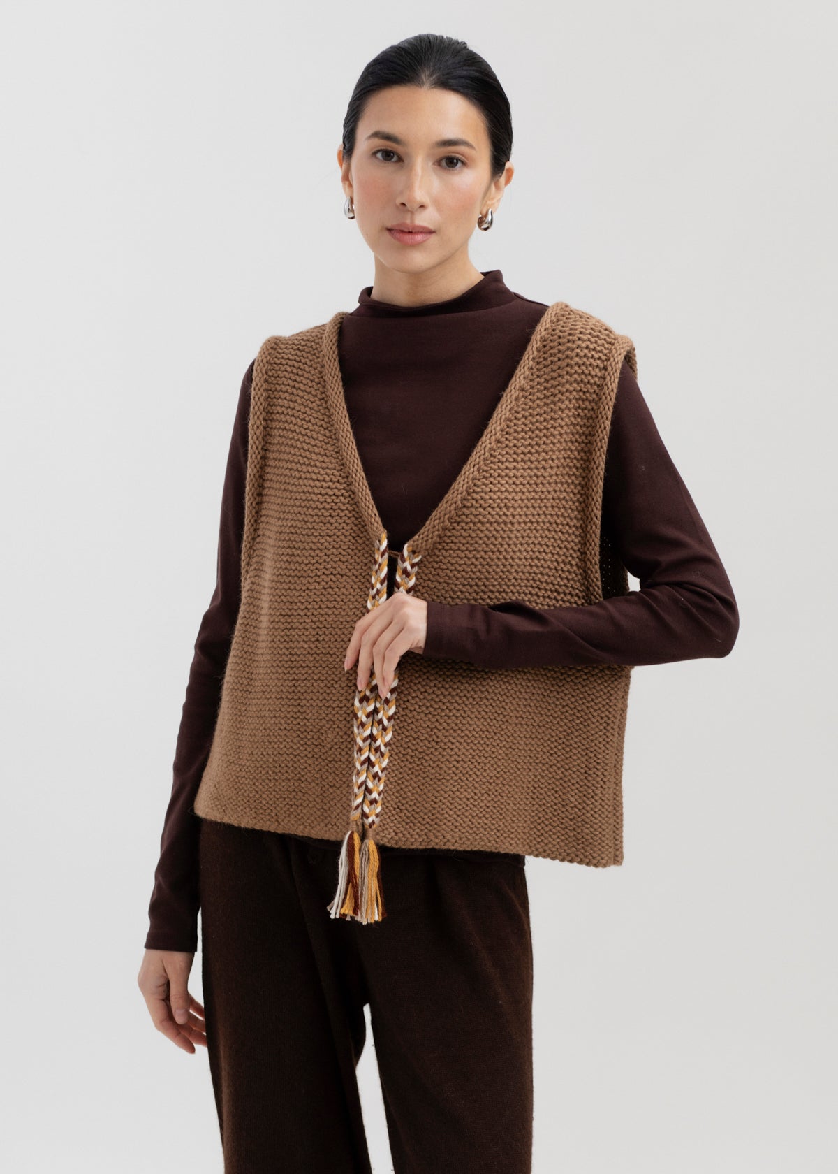Vela Braid Vest in Caramel, baby alpaca knit vest with hand-braided trim by Ahblo, worn by model