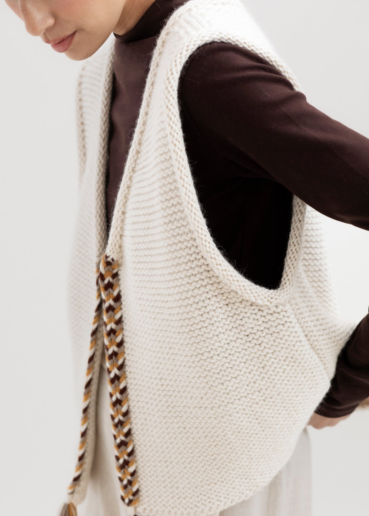Vela Braid Vest in Ivory, baby alpaca knit vest with hand-braided trim by Ahblo, worn by model