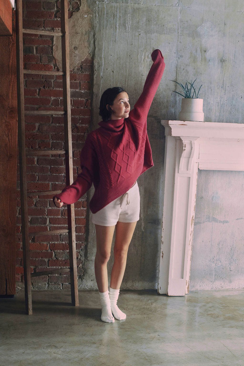 Model wearing oversized cable knit sweater in hot pink alpaca wool, standing