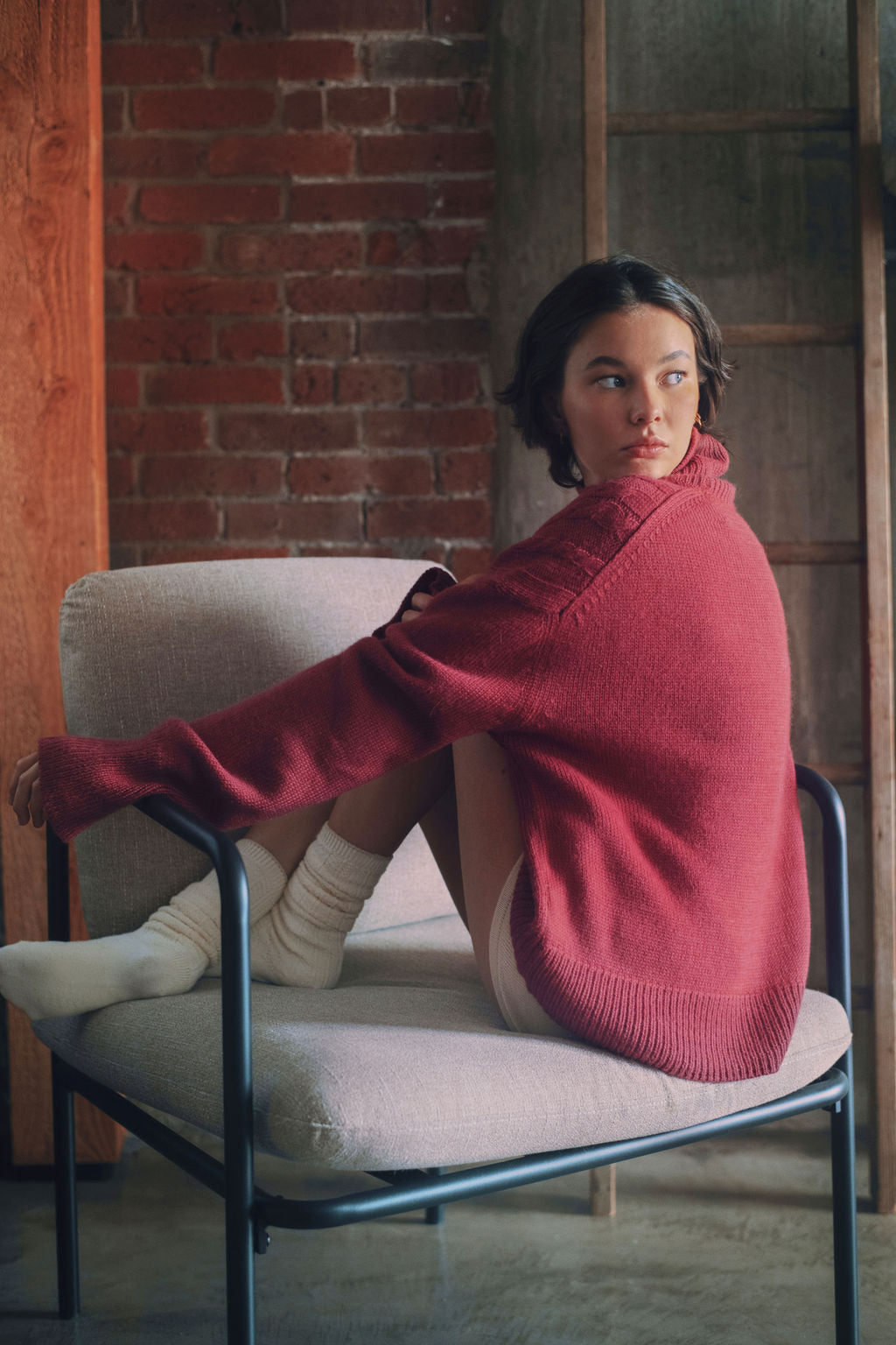 Model wearing oversized cable knit sweater in hot pink alpaca wool, side