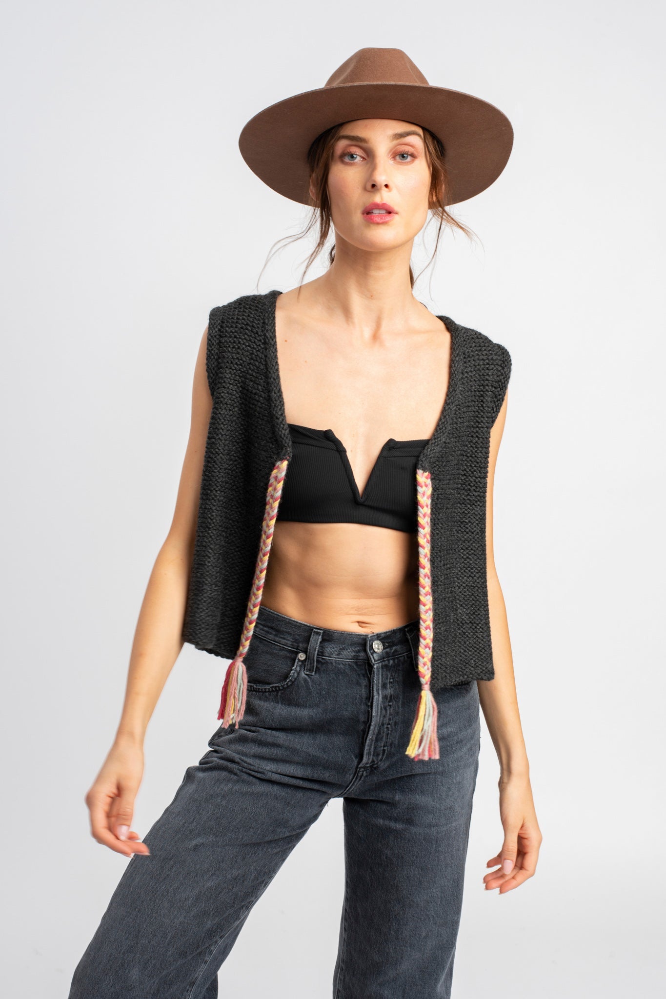 Model wearing dark grey knit vest in alpaca wool, front standing