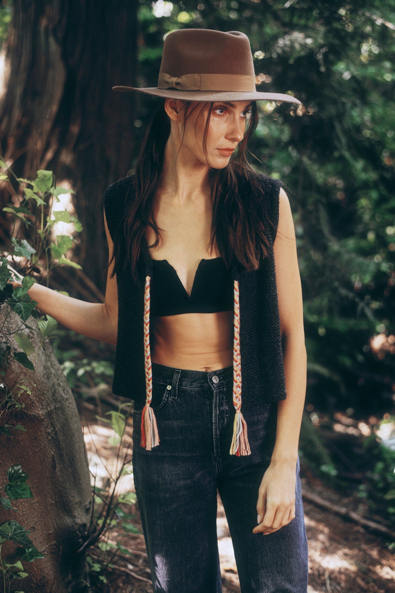 Model wearing dark grey knit vest in alpaca wool, standing outside