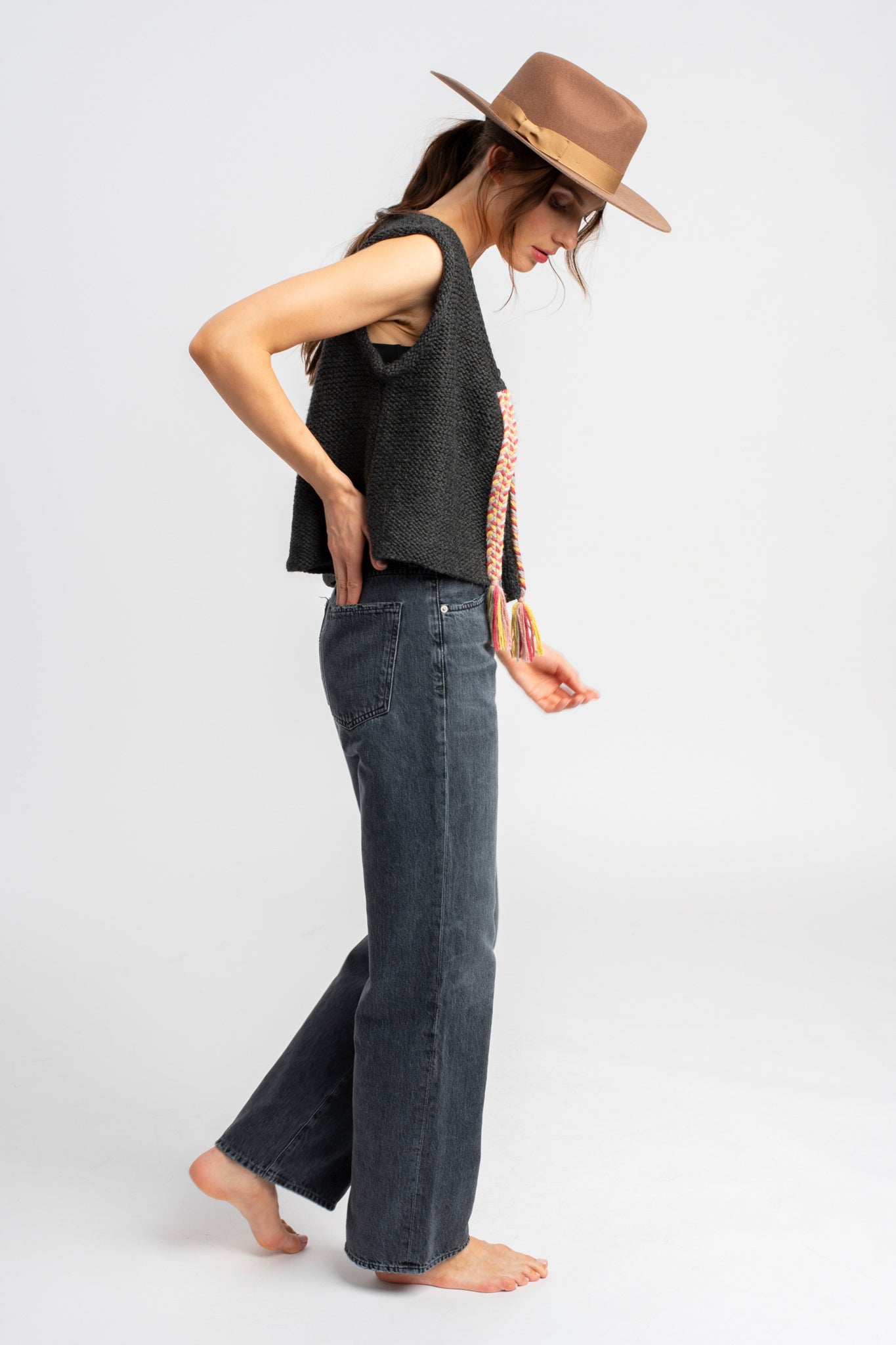 Model wearing dark grey knit vest in alpaca wool, side