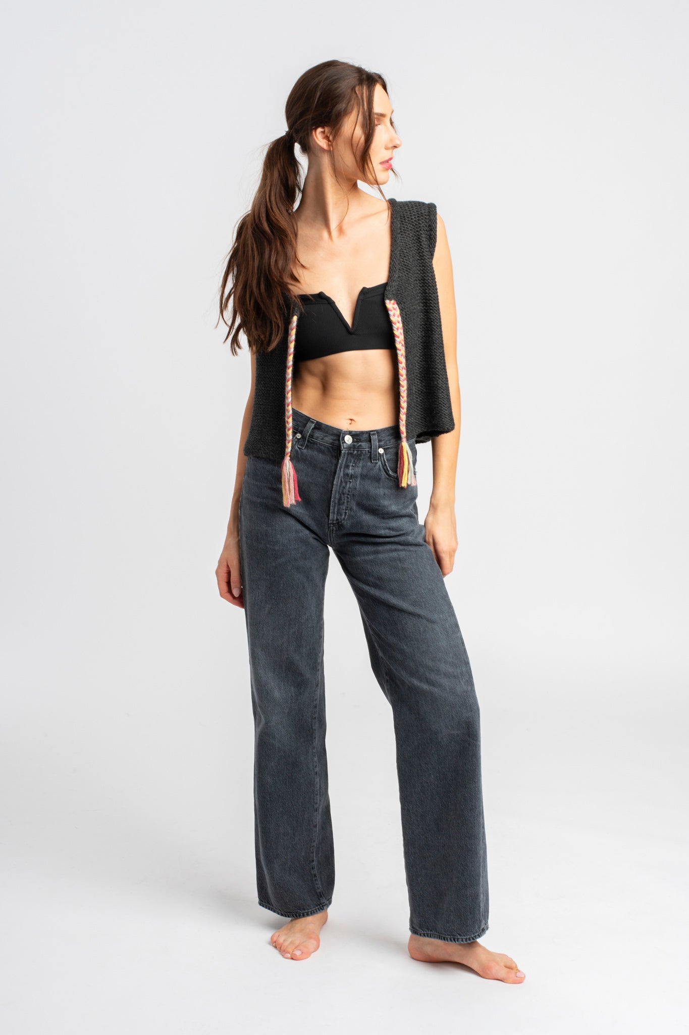 Model wearing dark grey knit vest in alpaca wool, front standing