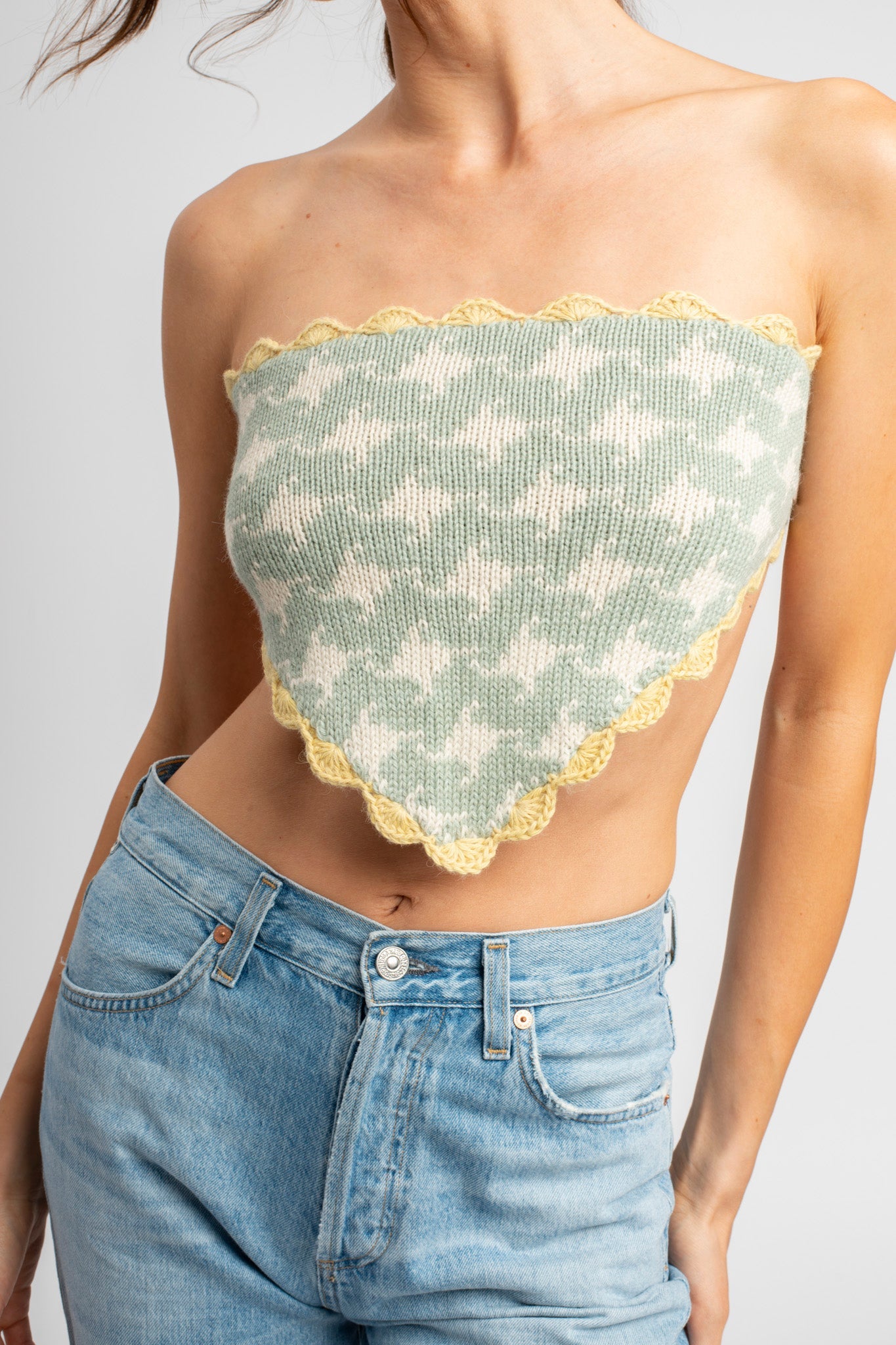 Model wearing knitwear, alpaca wool headscarf in white & sage on body, front close-up