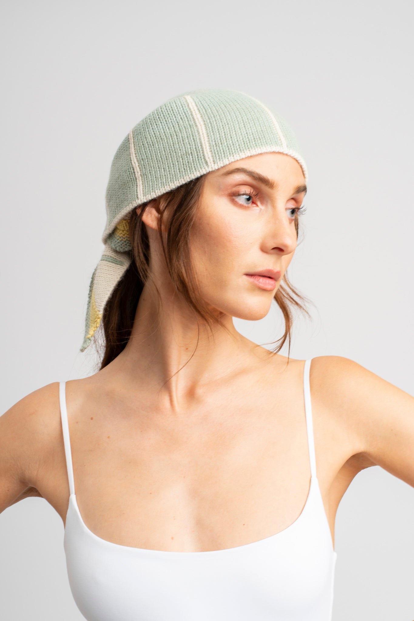 Model wearing knitwear headscarf alpaca wool in white & sage reversible stripes, front view