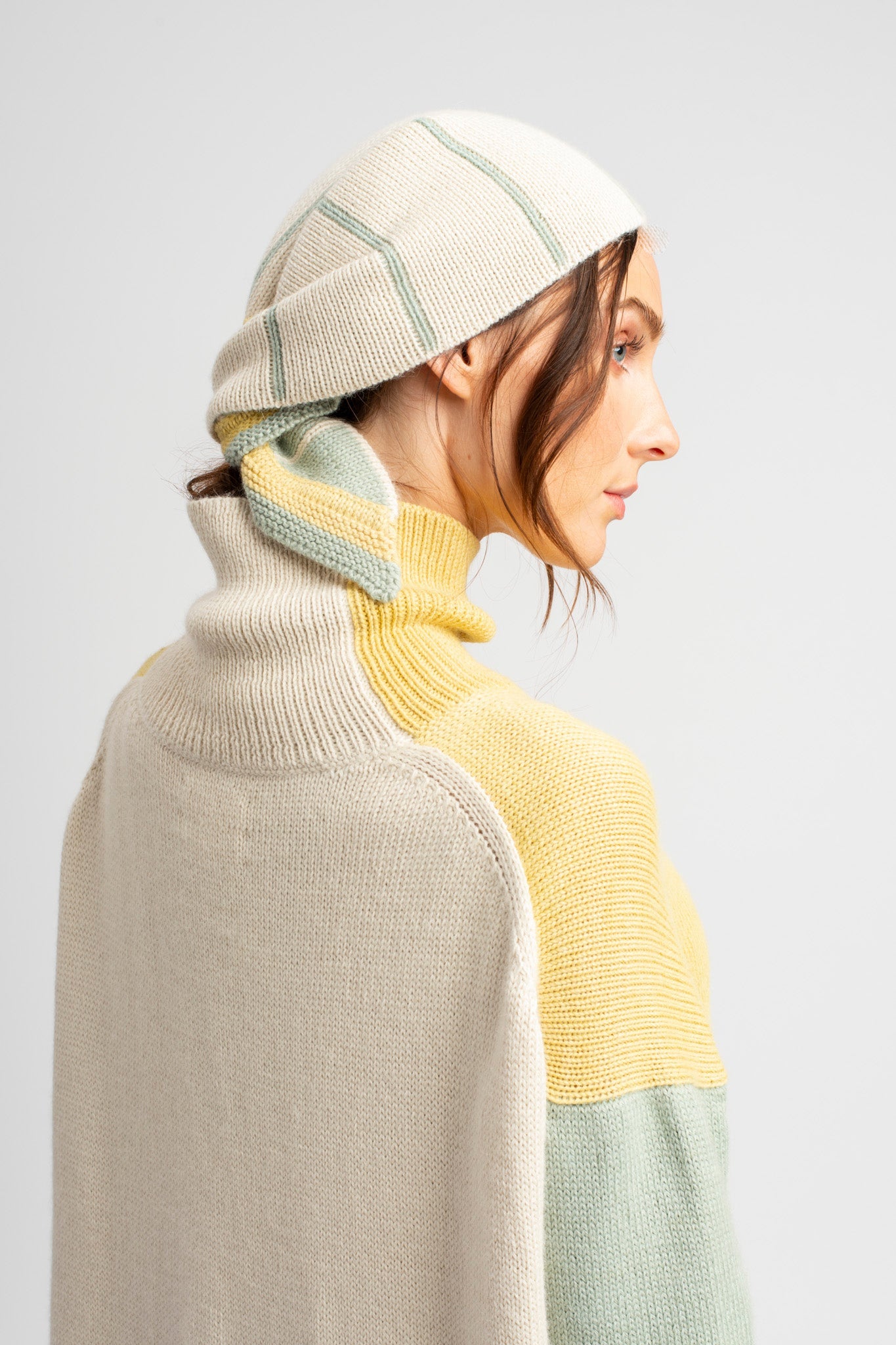 Model wearing knitwear headscarf alpaca wool in white & sage reversible stripes with oversized sweater