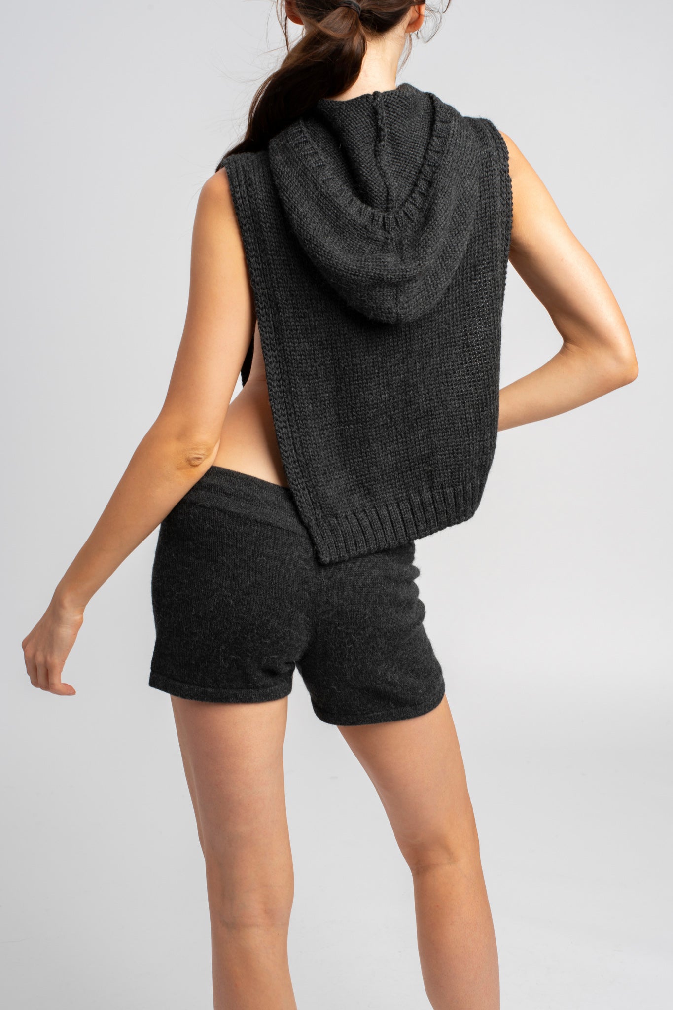 Model wearing knitwear alpaca wool dark grey shorts with matching poncho, back