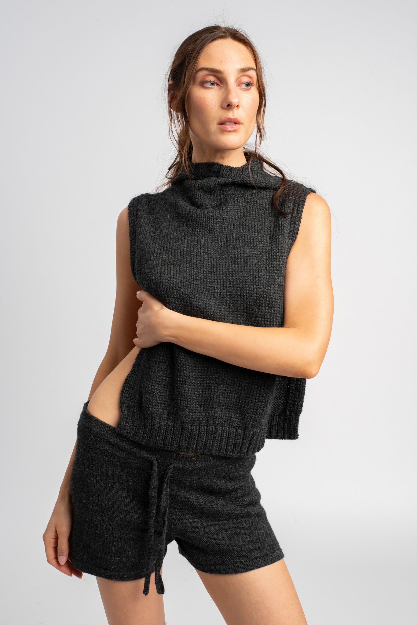 Model wearing knitwear alpaca wool dark grey shorts with matching poncho, front