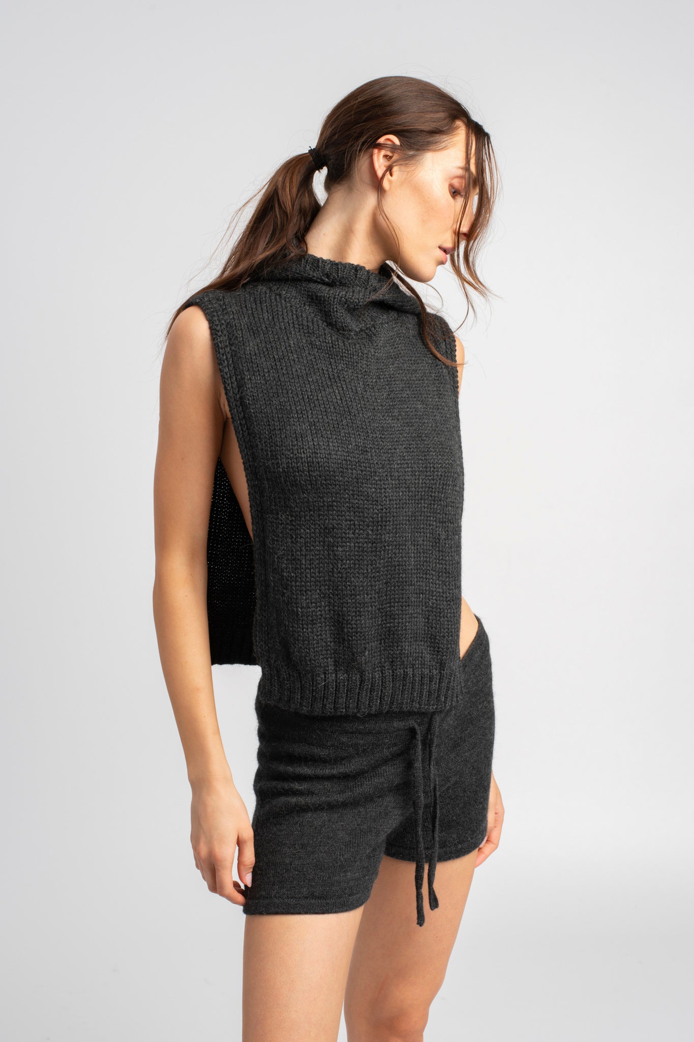 Model wearing knitwear alpaca wool dark grey shorts with matching knit poncho