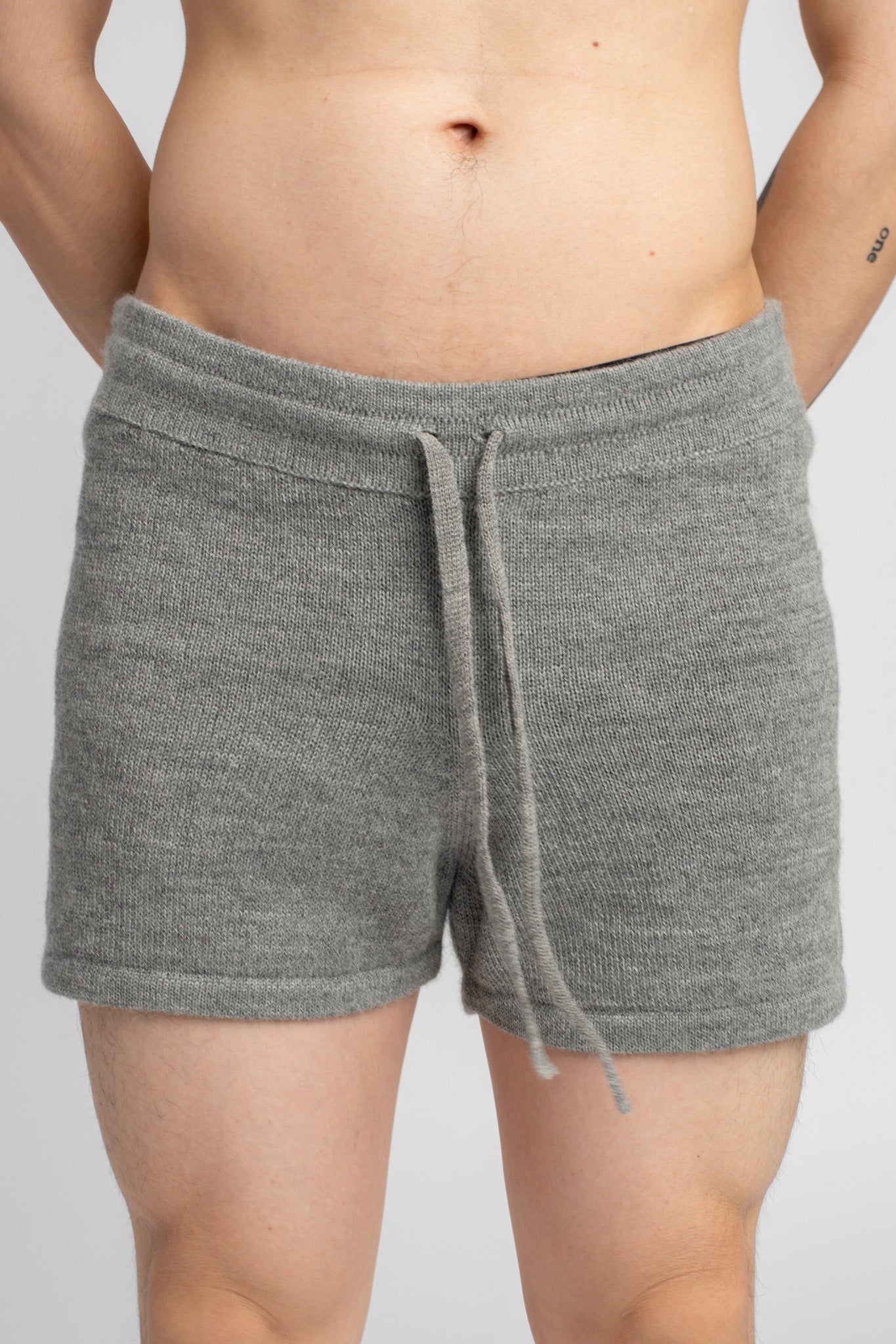 Model wearing knitwear alpaca wool light grey shorts, close-up