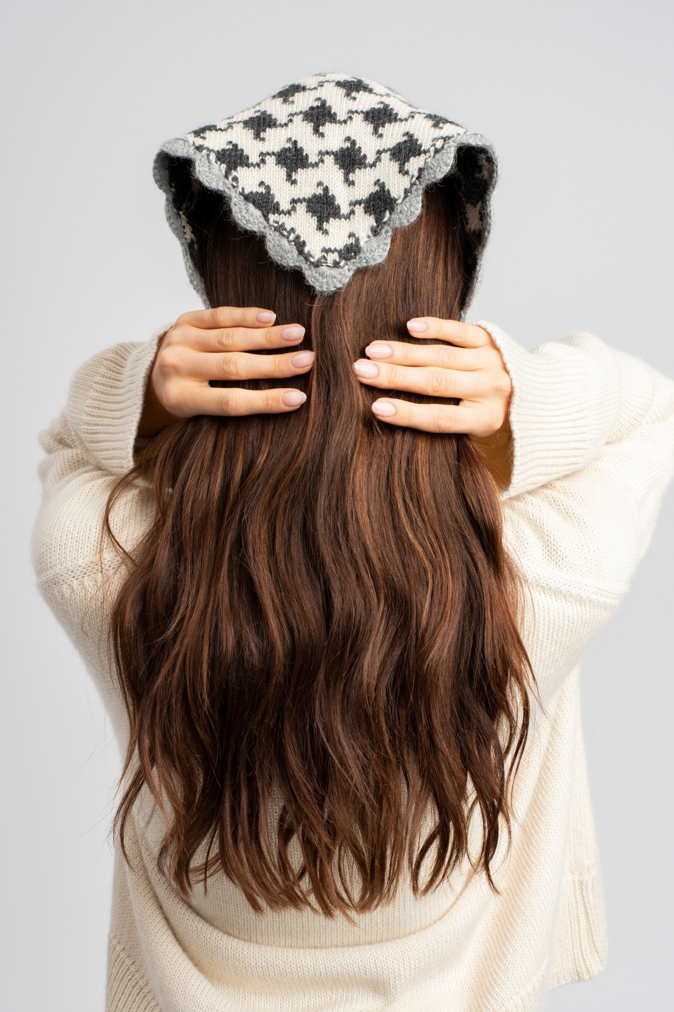Model wearing knitwear alpaca wool headscarf in white & grey reversible houndstooth, back