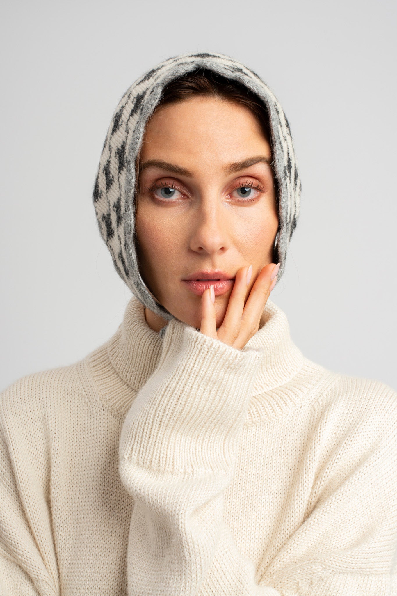 Model wearing knitwear alpaca wool headscarf in white & grey reversible houndstooth, front view