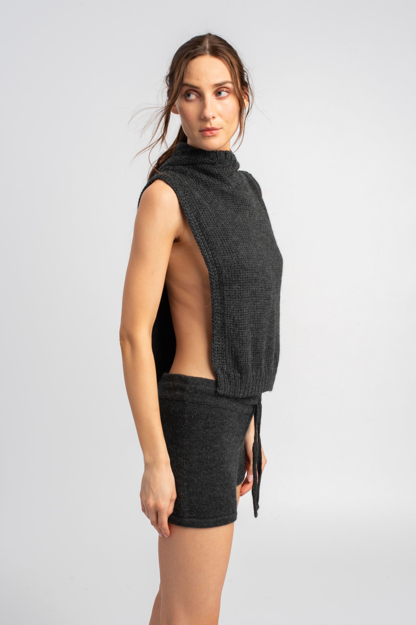 Model wearing knitwear alpaca wool dark grey shorts and knit poncho