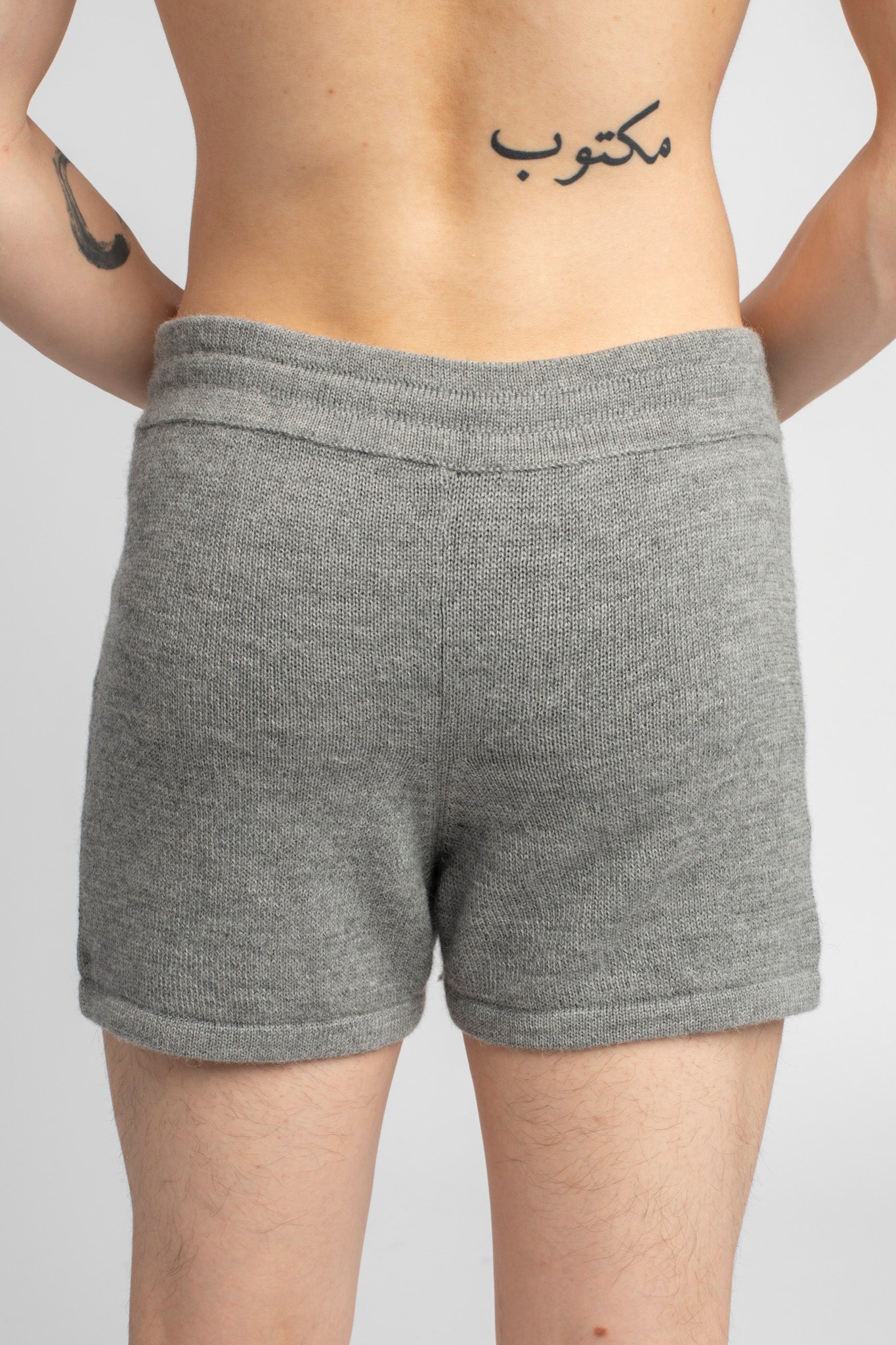 Model wearing knitwear alpaca wool light grey shorts, close-up back
