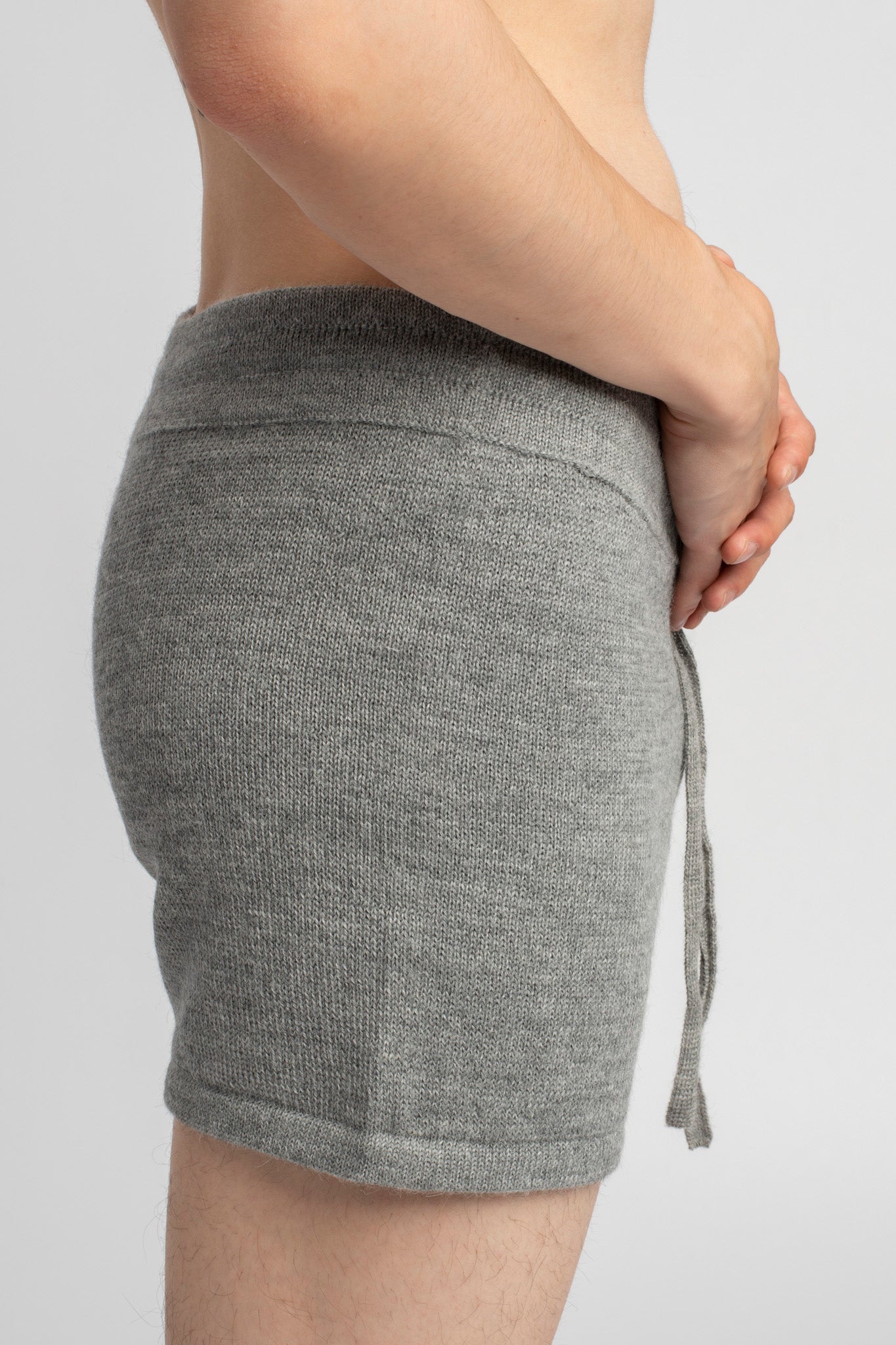 Model wearing knitwear alpaca wool light grey shorts, side close