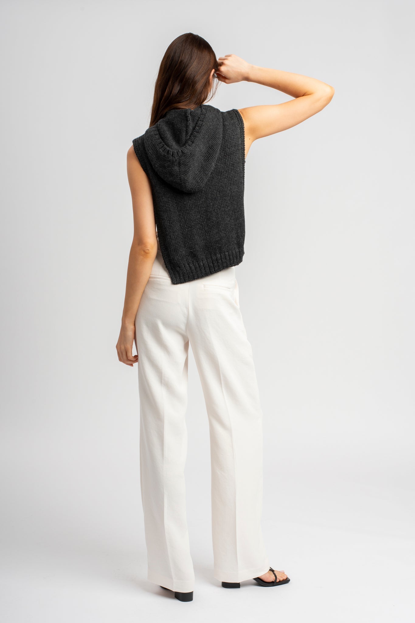 Model wearing poncho in dark grey alpaca wool, back standing