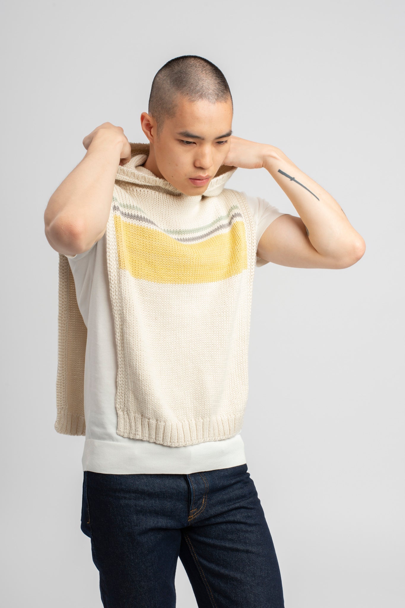 Model wearing poncho, alpaca wool in yellow ocean stripes with hood
