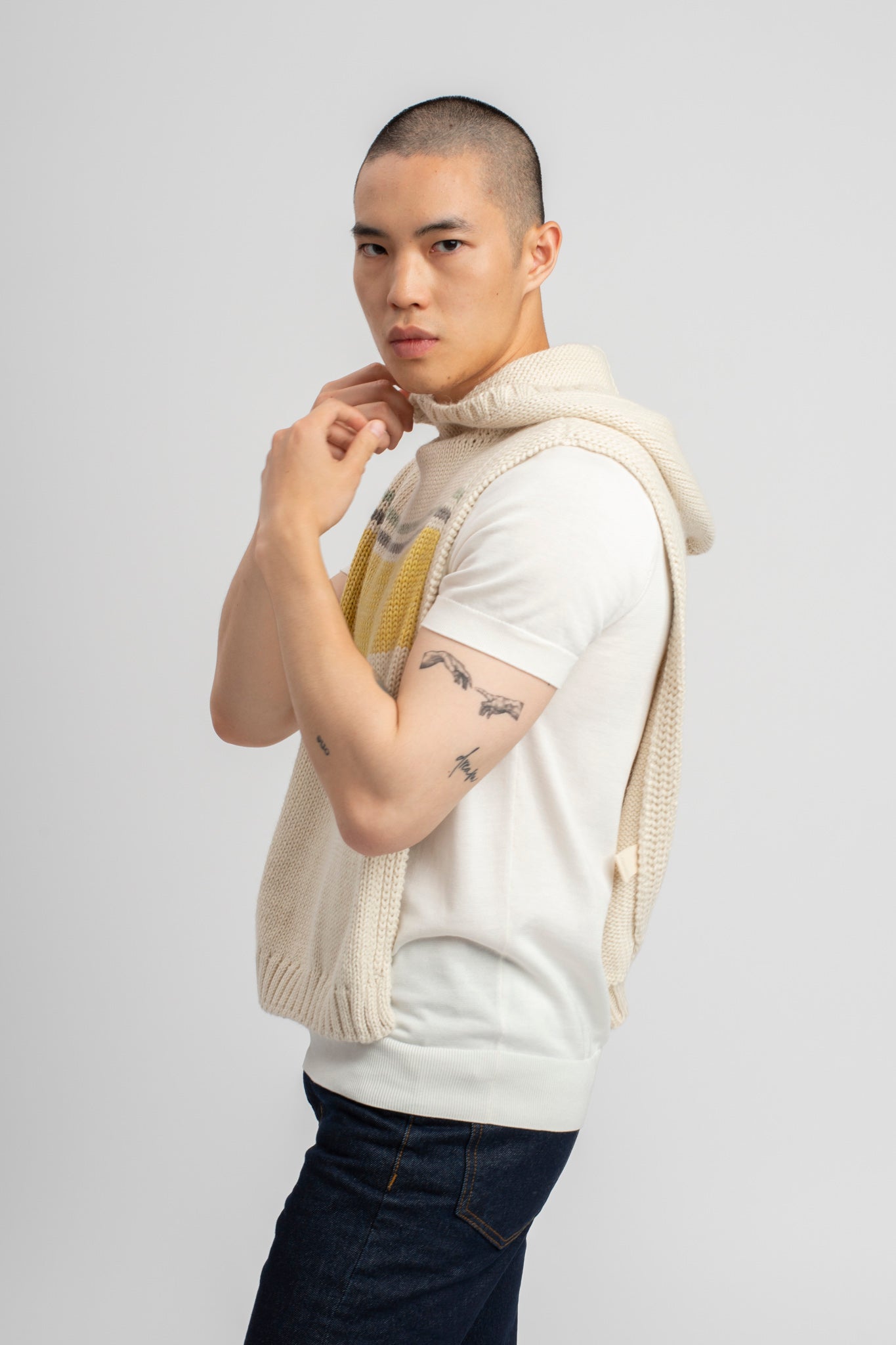 Model wearing poncho, alpaca wool in yellow ocean stripes, side