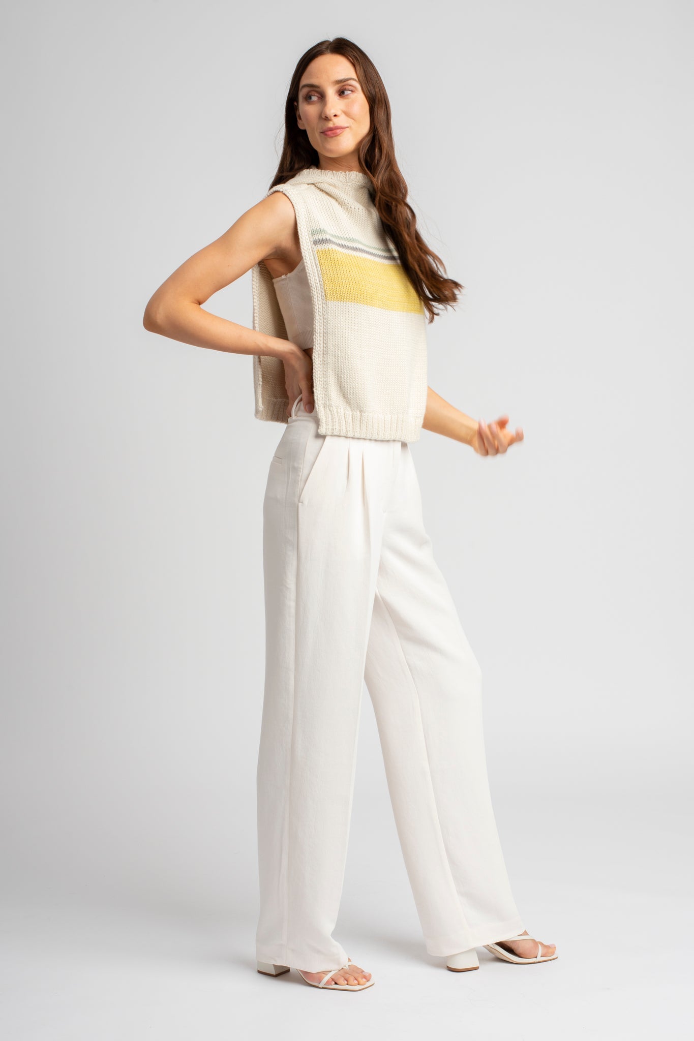 Model wearing poncho, alpaca wool in yellow ocean stripes, standing