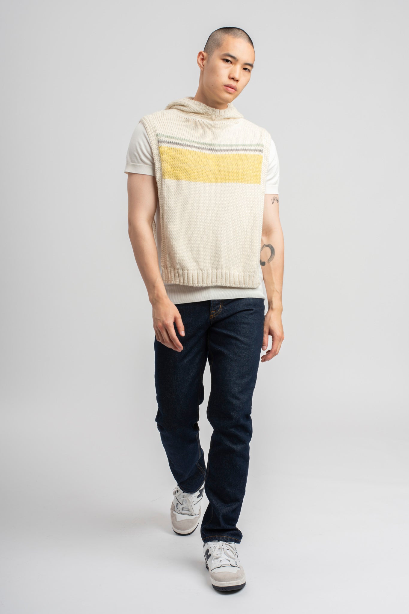 Model wearing poncho, alpaca wool in yellow ocean stripes, front standing