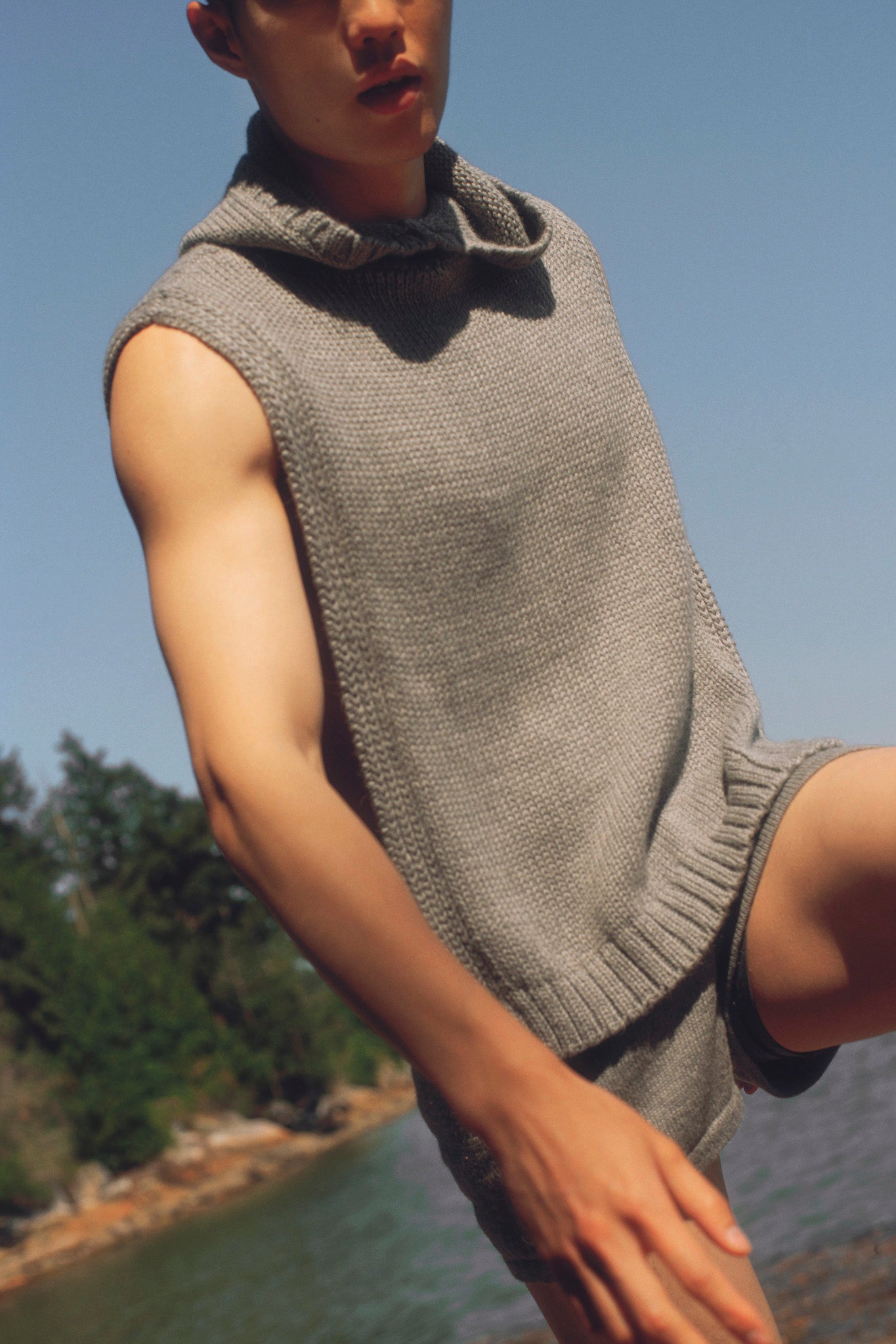 Model wearing poncho in light grey alpaca wool, close-up