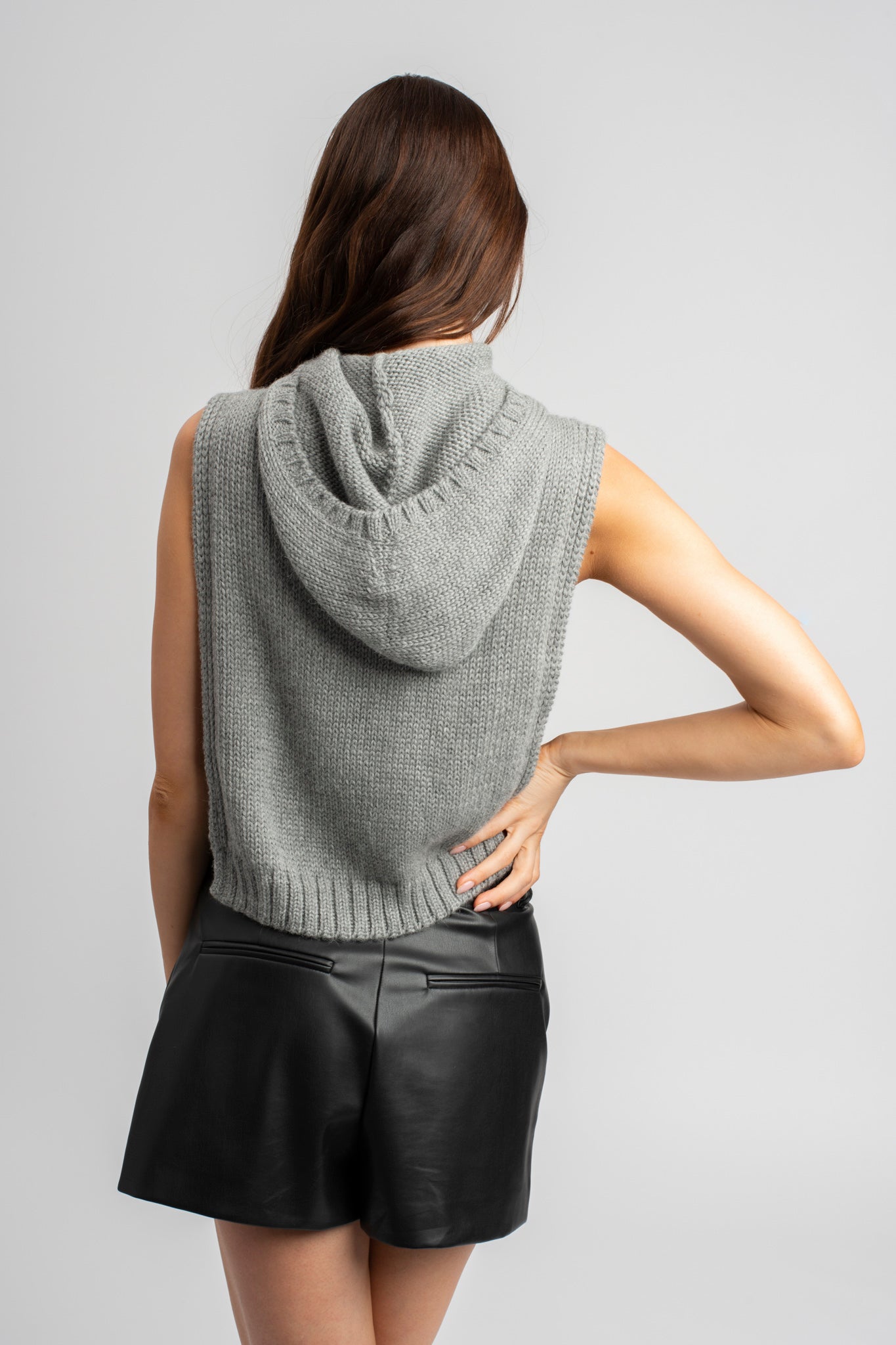 Model wearing poncho in light grey alpaca wool, back view