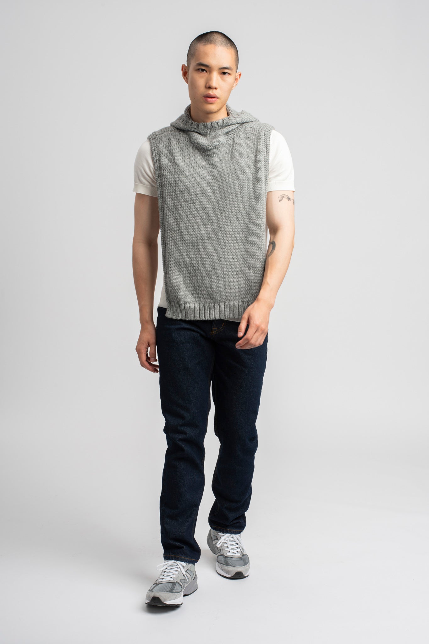 Model wearing poncho in light grey alpaca wool, front standing