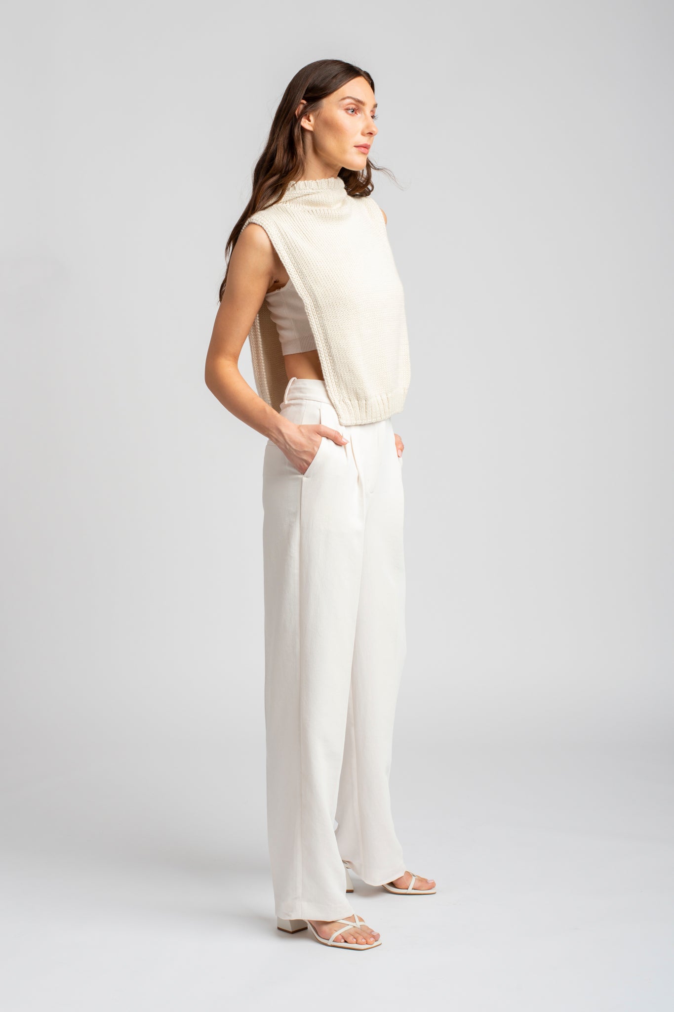 Model wearing poncho in white alpaca wool, side