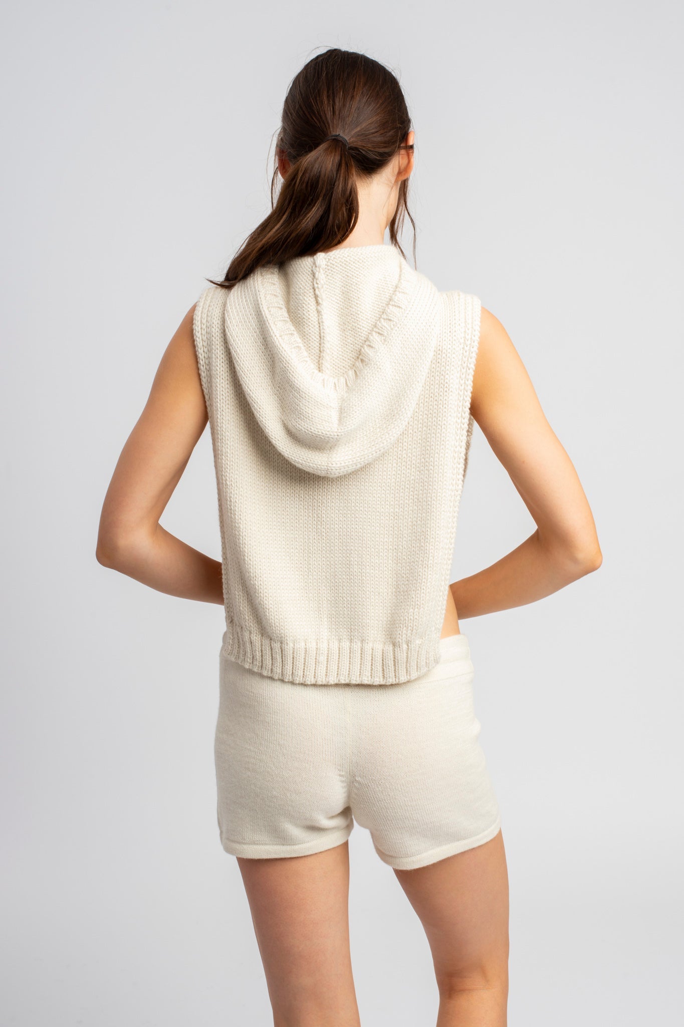 Model wearing poncho in white alpaca wool, back close-up