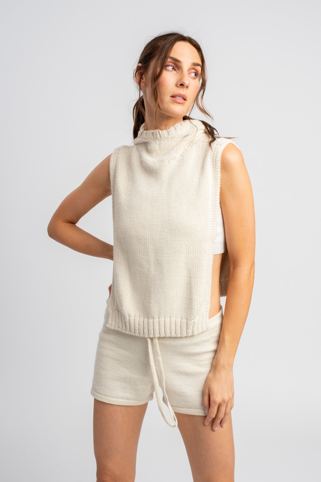 Model wearing poncho in white alpaca wool with matching shorts, front