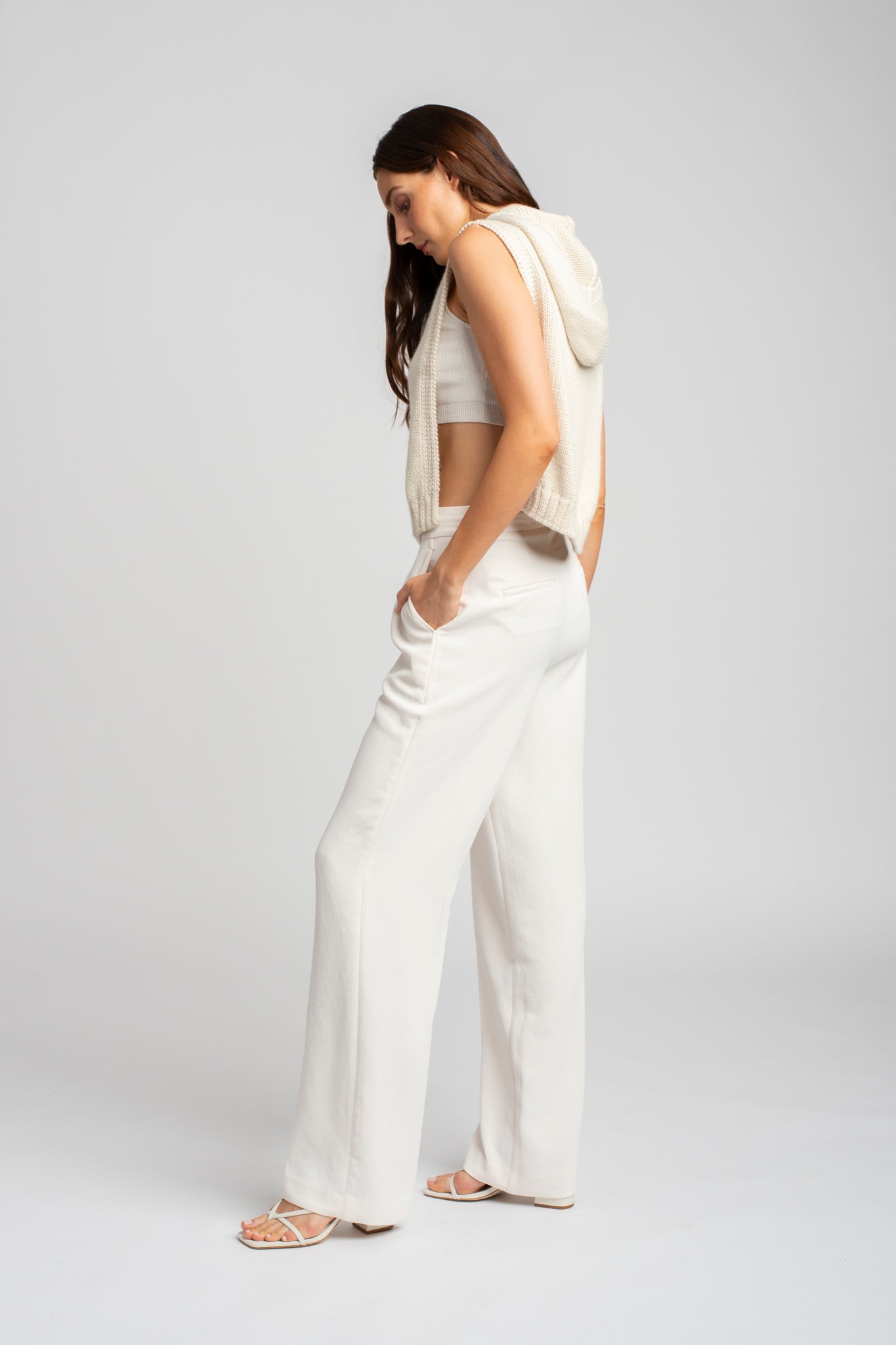 Model wearing poncho in white alpaca wool, side standing