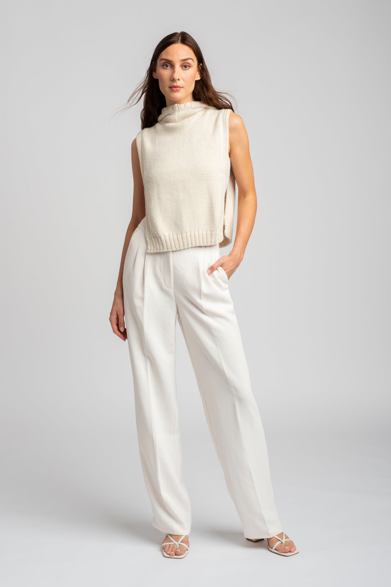 Model wearing poncho in white alpaca wool, standing