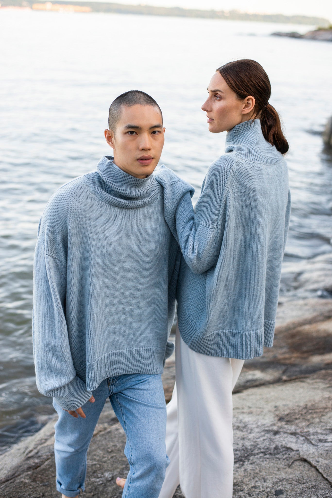 Two model wearing turtleneck oversized sweaters in blue alpaca wool