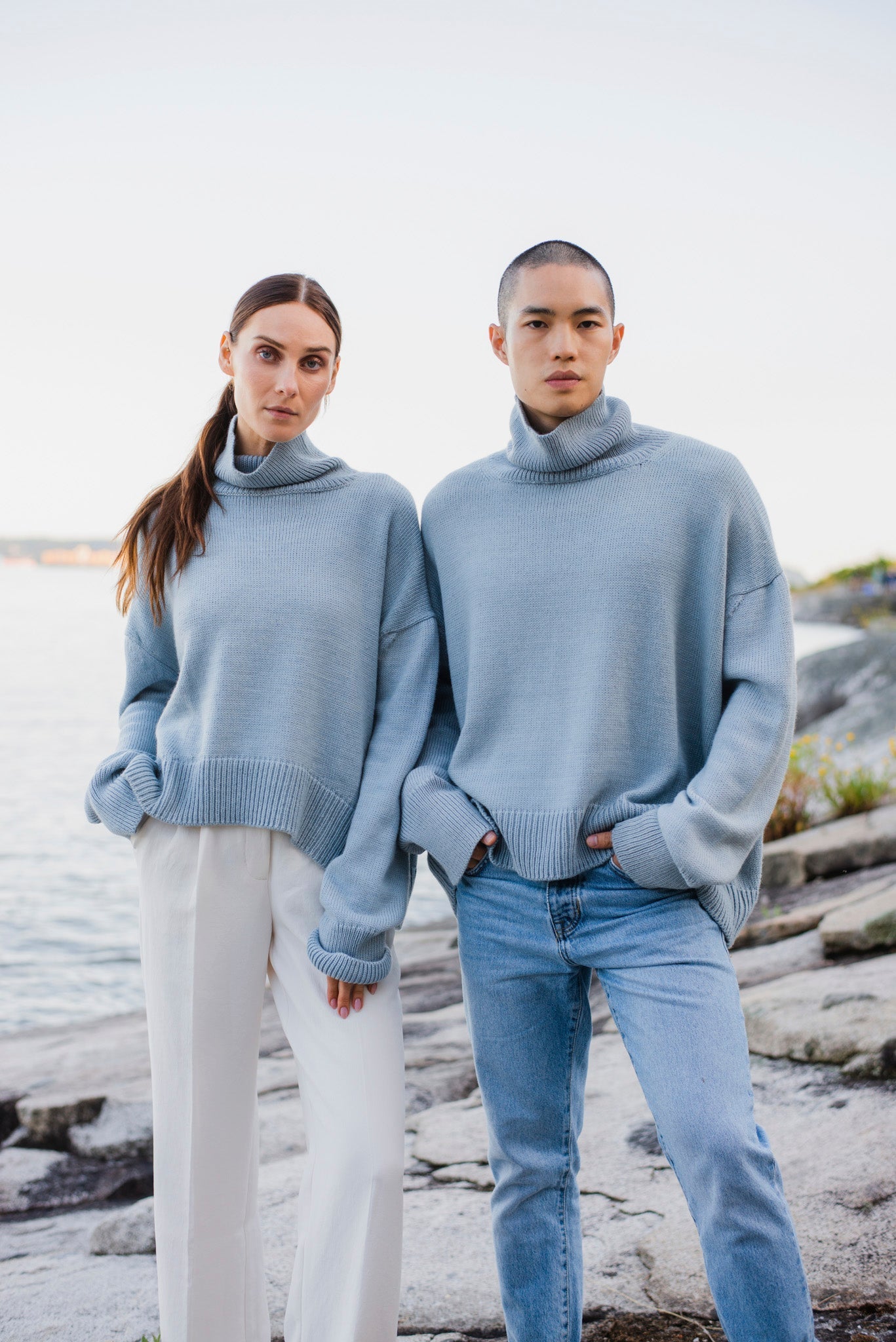 Two model wearing turtleneck oversized sweaters in blue alpaca wool, front