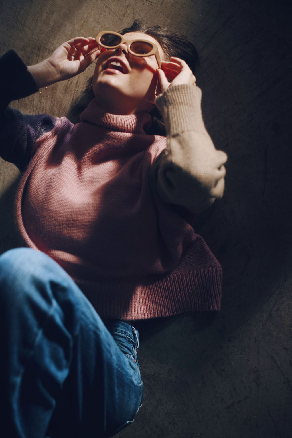 Model wearing oversized sweater in multi-color pink alpaca wool, sitting