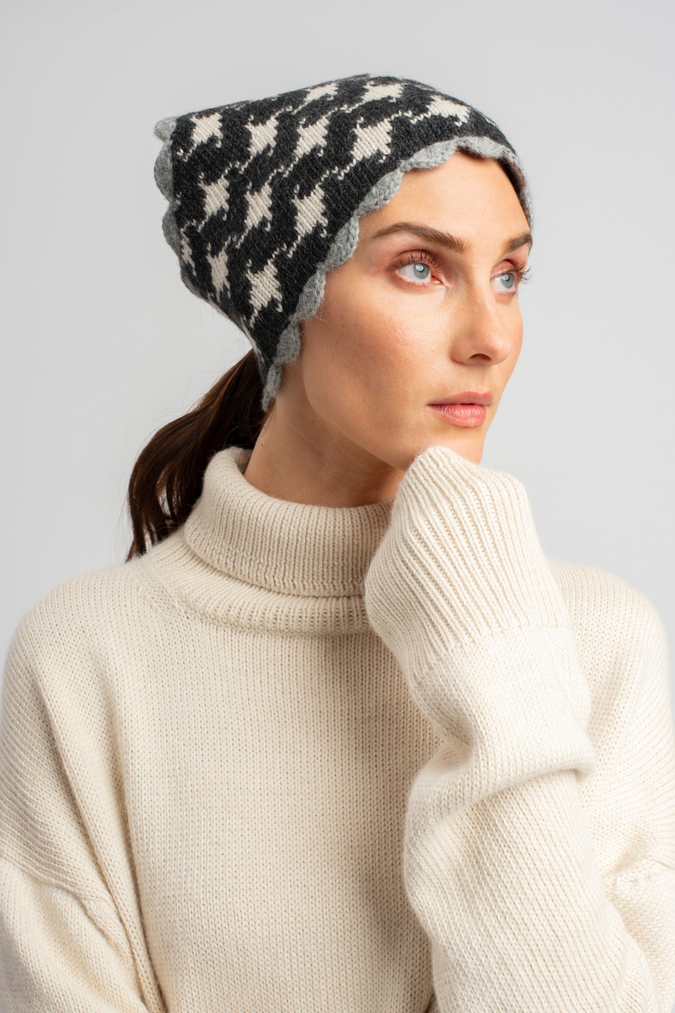 Model wearing turtleneck oversized sweater in white alpaca wool, close-up