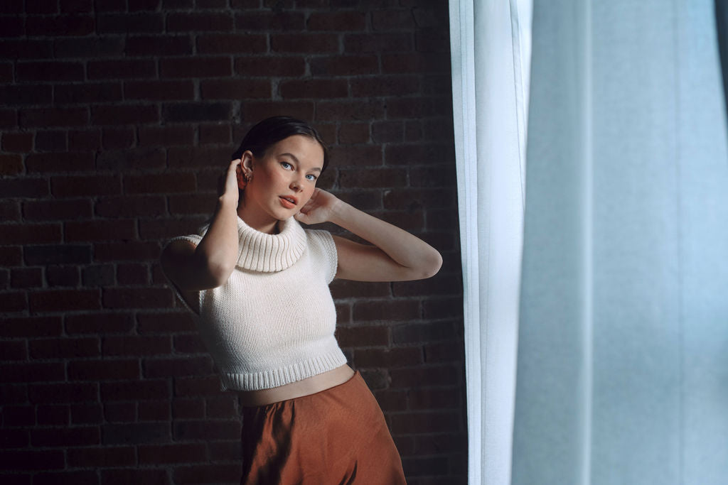 Model wearing white sweater crop top in alpaca wool, front distance