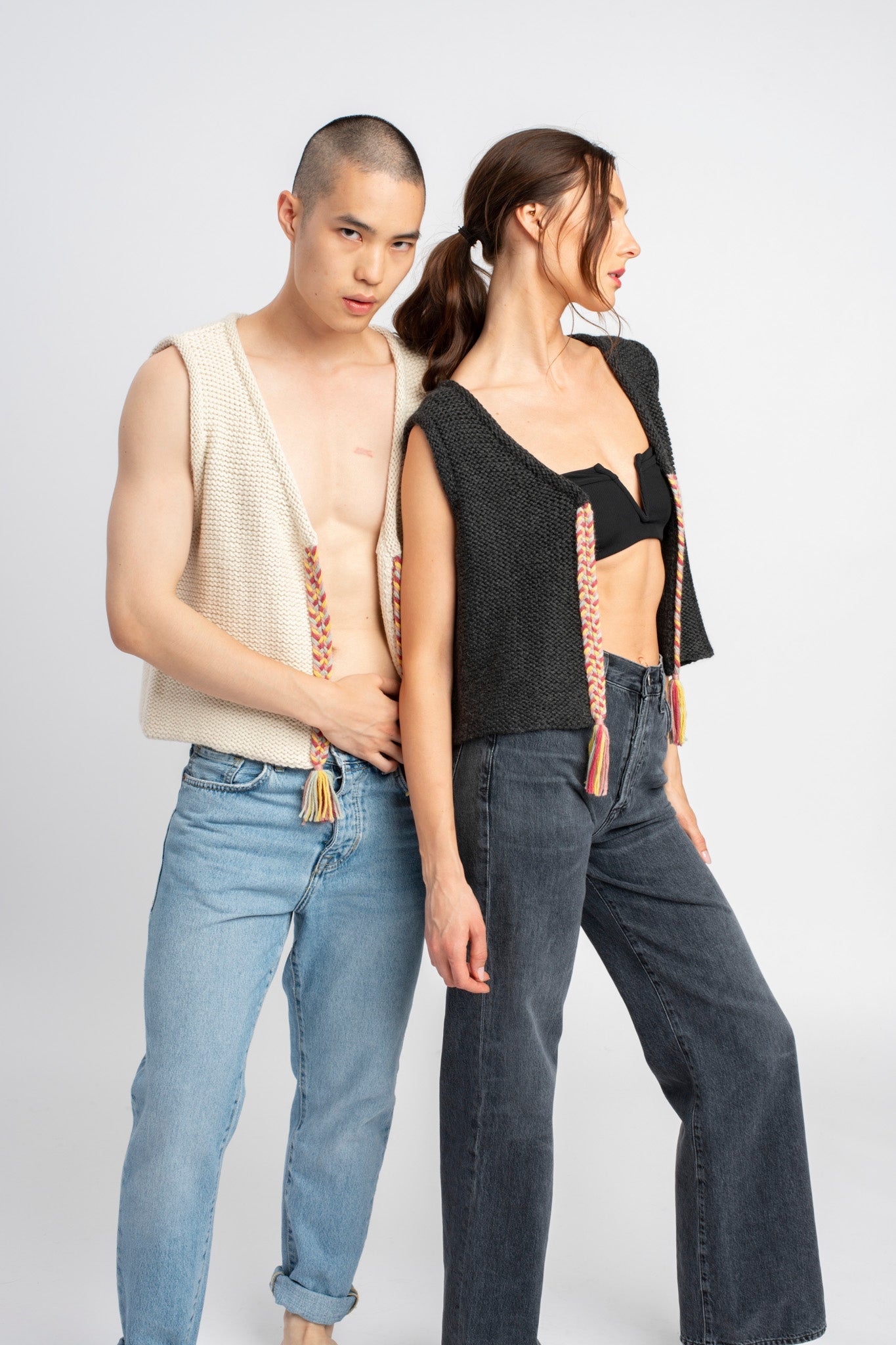 Two models wearing white sweater knit vests in alpaca wool, standing side by side