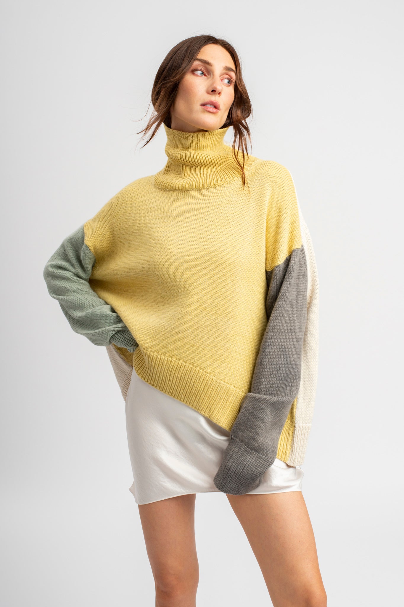 Model wearing turtleneck oversized sweater in multi-color yellow alpaca wool, front view