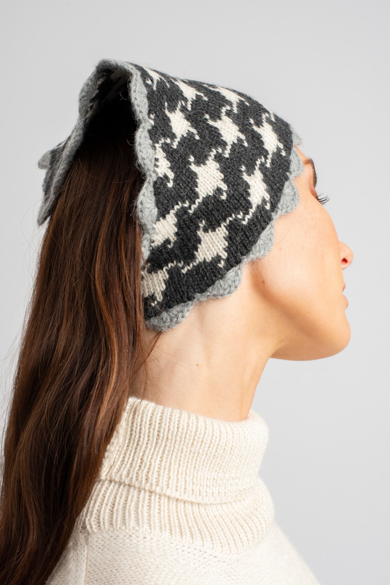 Model wearing knitwear alpaca wool headscarf in white & grey reversible houndstooth, side close