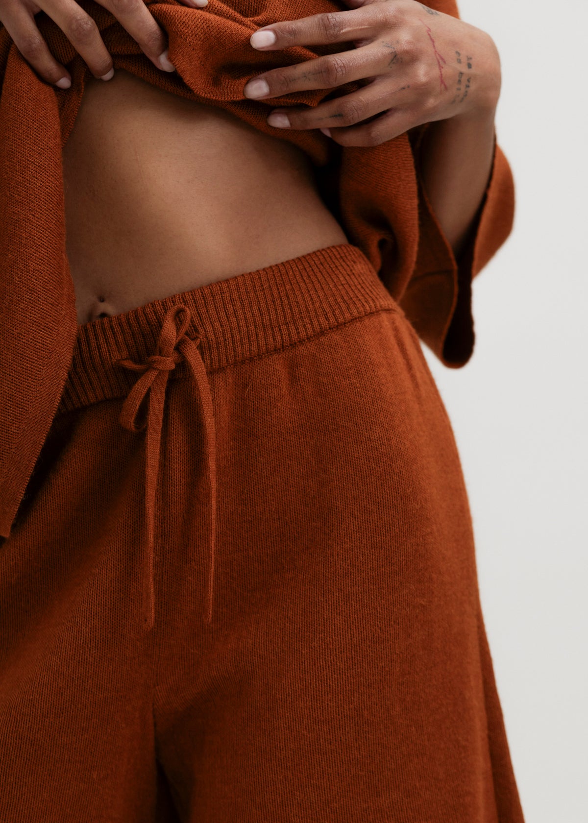 Airy Shorts in Burnt Orange, alpaca and silk knit shorts by Ahblo, worn by model