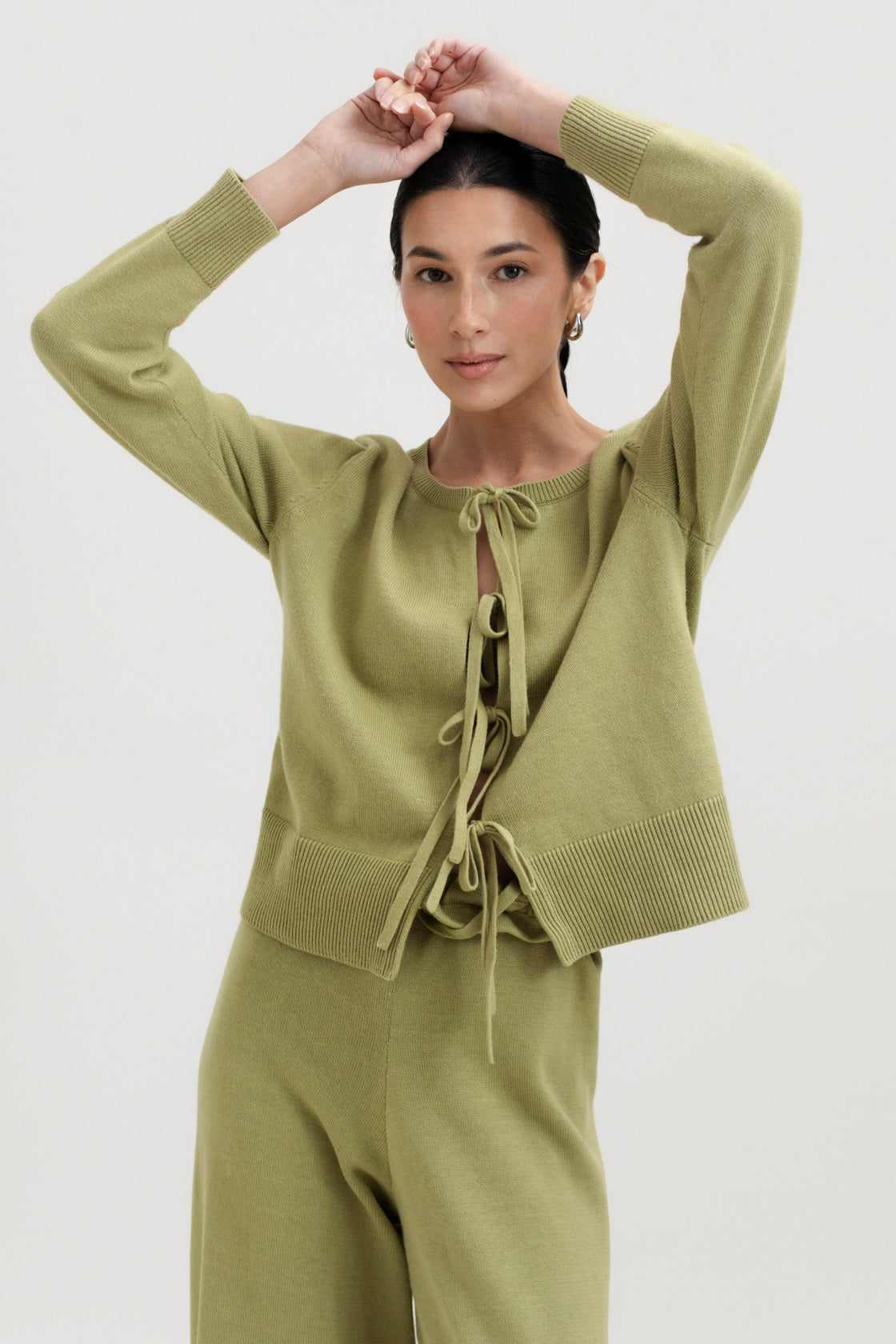 Amaya Cardigan in Olive, cotton and baby alpaca bow cardigan by Ahblo, worn by model