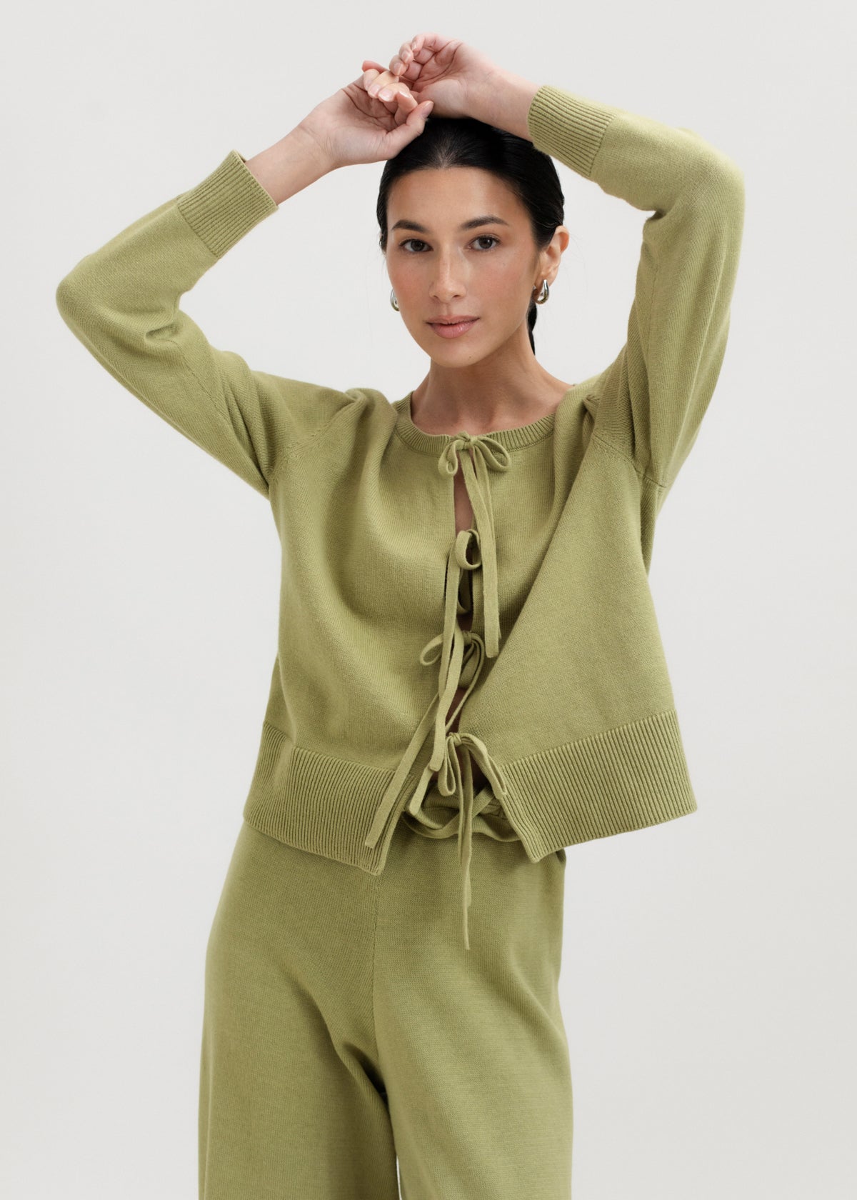Amaya Cardigan in Olive, cotton and baby alpaca bow cardigan by Ahblo, worn by model