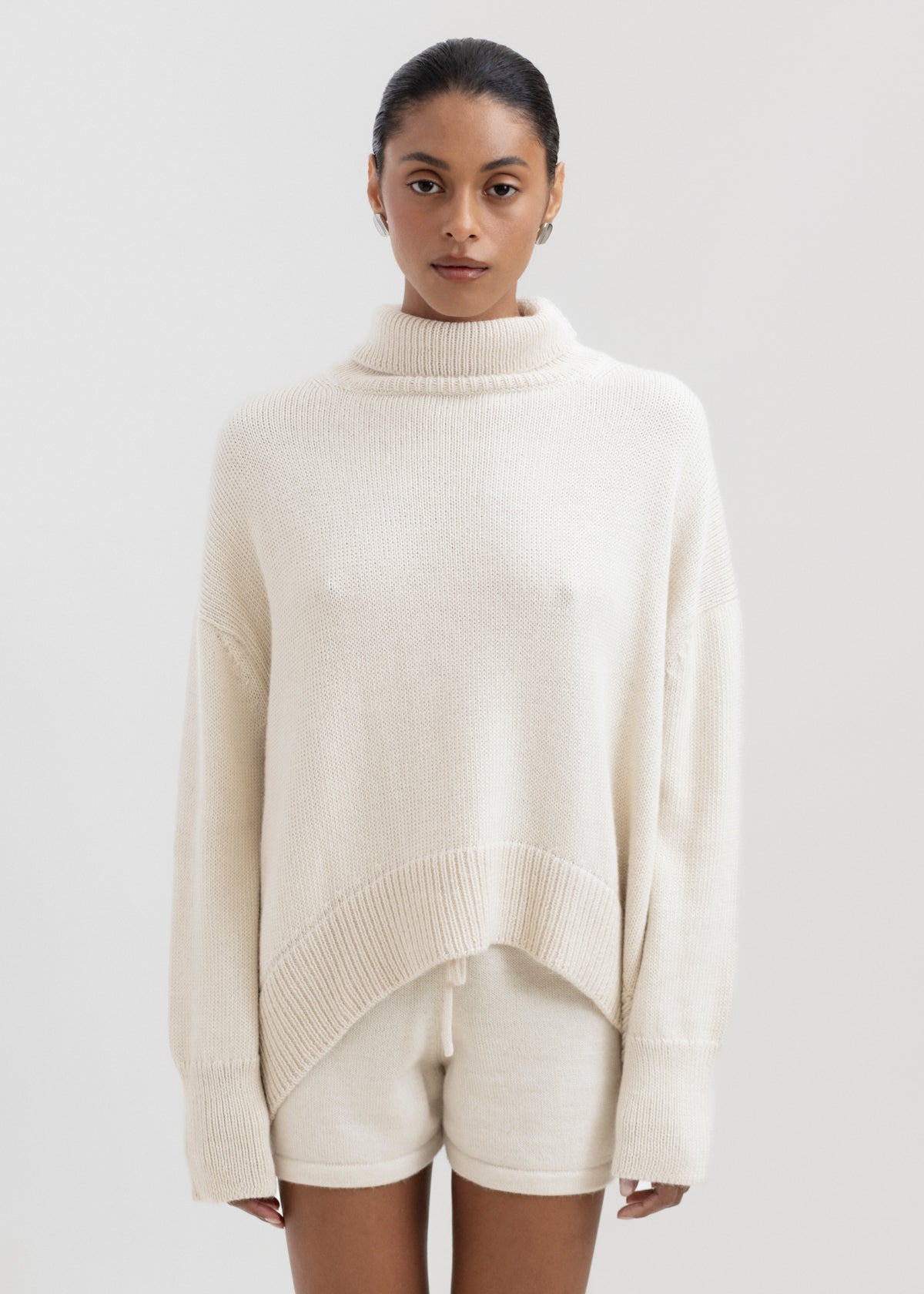 Cove Shorts in Cream, baby alpaca knit shorts by Ahblo, worn by model