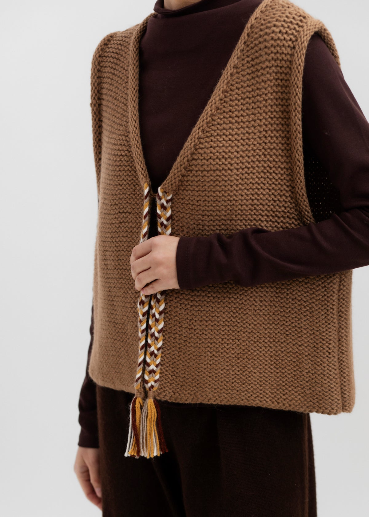 Vela Braid Vest in Caramel, baby alpaca knit vest with hand-braided trim by Ahblo, worn by model
