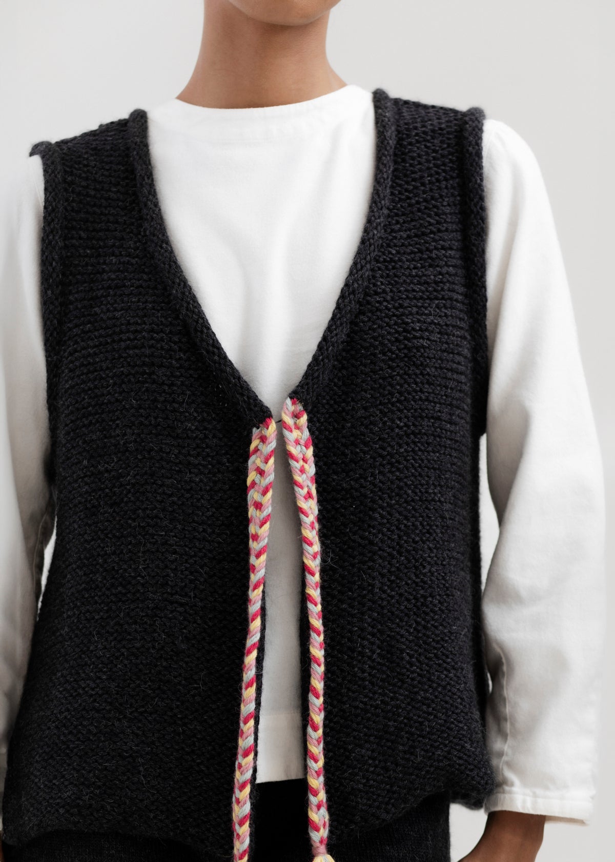 Vela Braid Vest in Charcoal, baby alpaca knit vest with hand-braided trim by Ahblo, worn by model